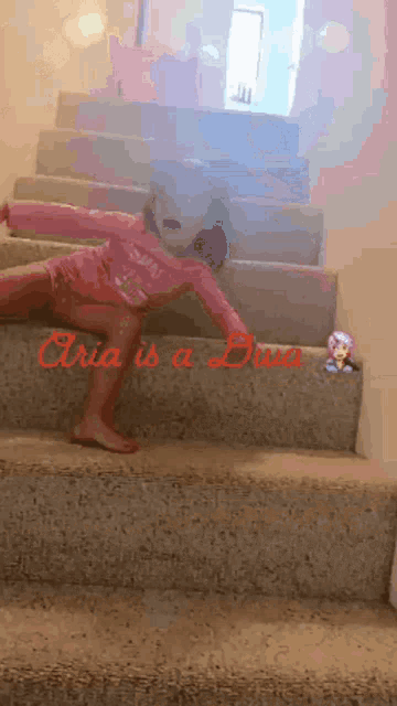 a little girl is sitting on a set of stairs with the words " aria is a diva " in red