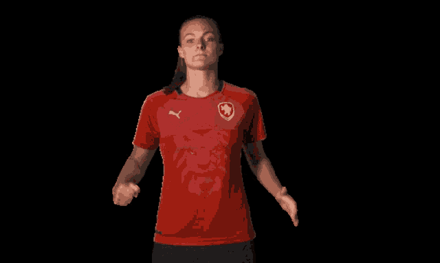 a woman in a red shirt with a lion on it is giving the middle finger