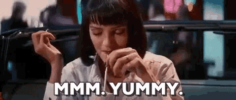 a woman is sitting in a car eating food and saying `` mmm . yummy '' .