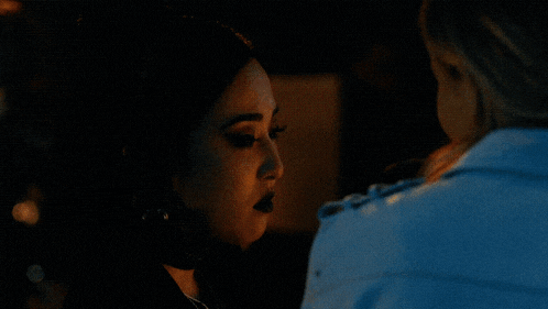 a man and a woman are hugging in a dark room