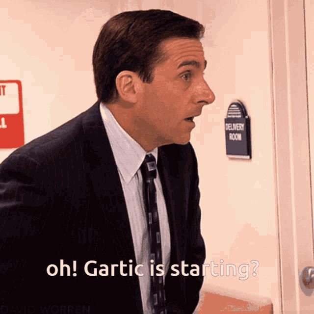 a man in a suit and tie says oh gartic is starting in front of a delivery room sign
