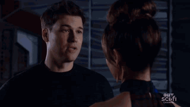 a man and a woman are looking at each other in front of a blue background .