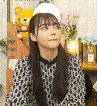 a young girl wearing a white hat and a black and white shirt is making a funny face .