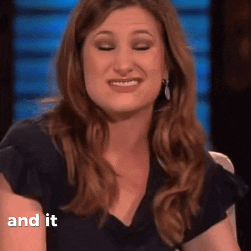 a woman in a black shirt is smiling with the words " and it " next to her