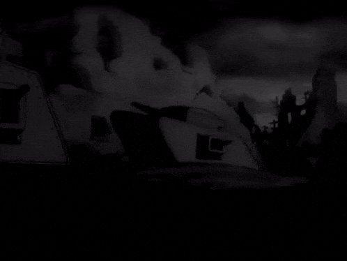 a black and white photo of a destroyed building with smoke coming out of it