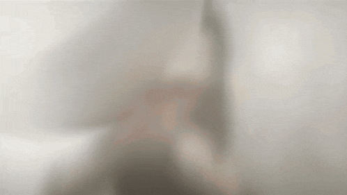 a blurred image of a person behind a glass door