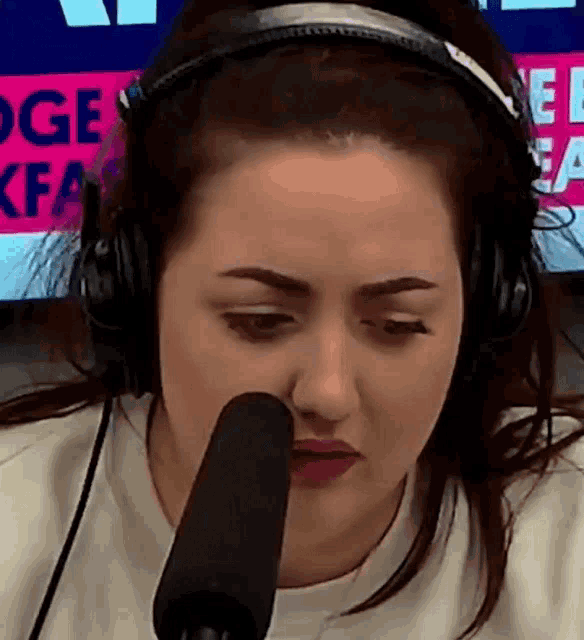 a woman is wearing headphones and looking at a microphone