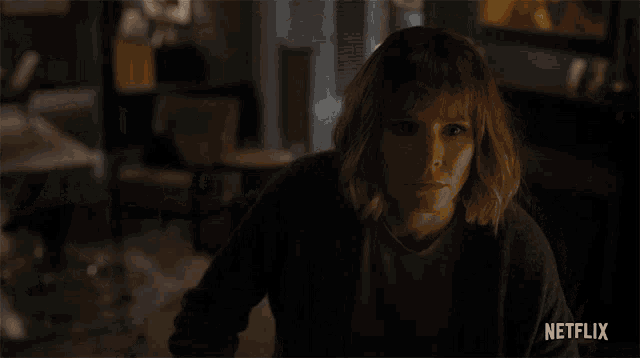 a woman in a dark room with a netflix logo on the bottom right