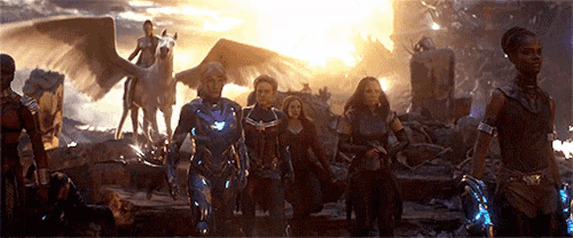 a group of avengers are standing next to each other in a field .