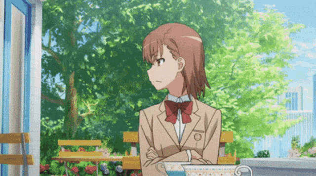 a girl in a school uniform sits at a table with her arms crossed and a cup of tea