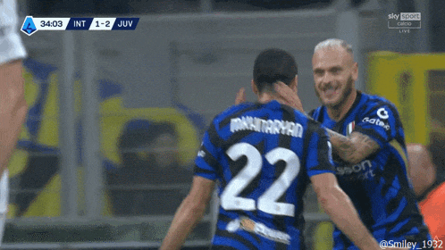 a soccer player with the number 22 on his jersey is hugging another player