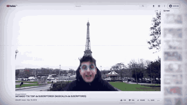 a screenshot of a youtube video with a man wearing glasses and the eiffel tower in the background