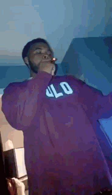 a man wearing a purple shirt that says olo on it