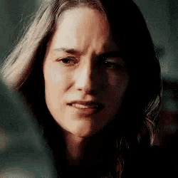 a close up of a woman 's face with a sad expression on her face .
