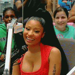 a woman in a red tank top is smiling in front of a microphone