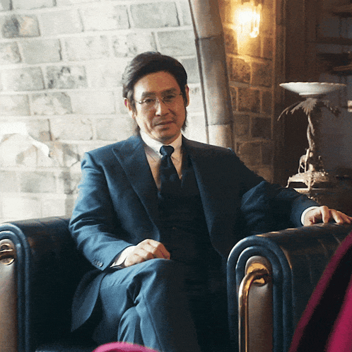 a man in a suit is sitting in a chair