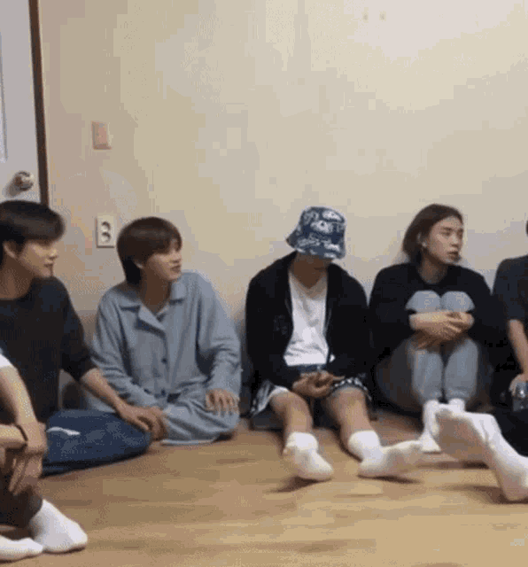 a group of people are sitting on the floor wearing socks and a hat .