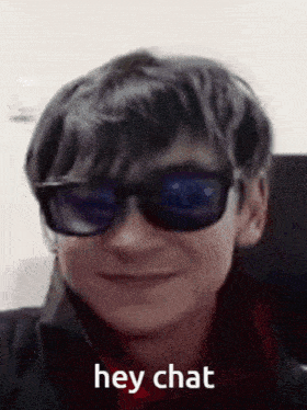 a boy wearing sunglasses is smiling and saying hey chat .