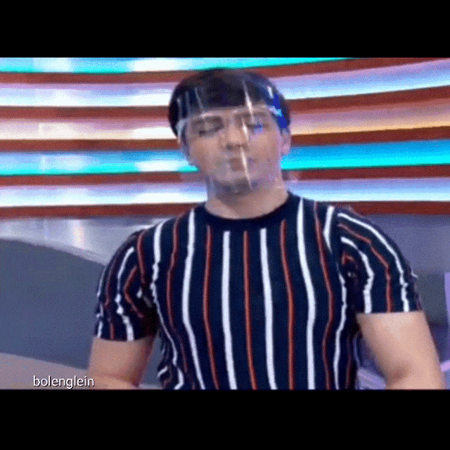 a man in a striped shirt is wearing a face shield .
