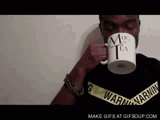 a man is drinking from a mug that says " mug of tea "