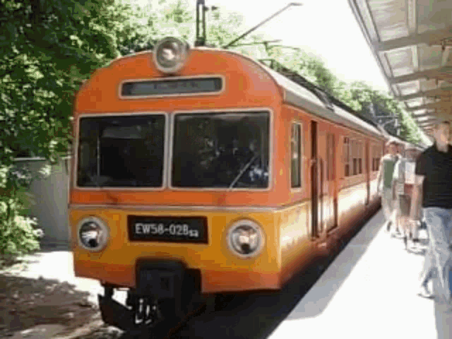 a yellow and orange train with the number ew58-028 on it