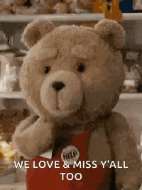 a teddy bear is wearing a red apron and holding a heart .