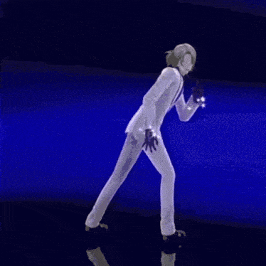 a man in a white suit is dancing on a stage in front of a crowd .
