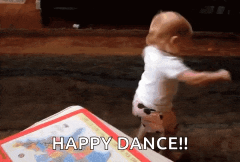 a baby is dancing on a table with the words `` happy dance '' written on it .