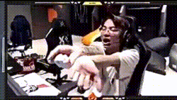 a man wearing headphones is sitting at a desk with his hands on his arms