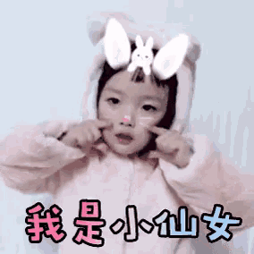 a little girl wearing a cat costume with bunny ears on her head .