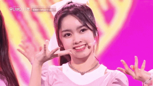 a girl with a bow in her hair is smiling and making a funny face
