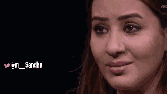 a close up of a woman 's face with a twitter account @m_sandhu below her