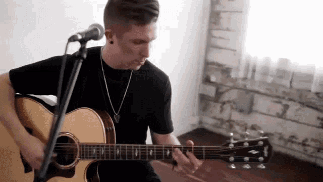 a man is singing into a microphone while playing a guitar