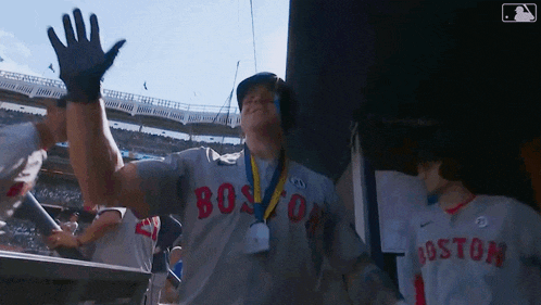 a man wearing a boston jersey is waving