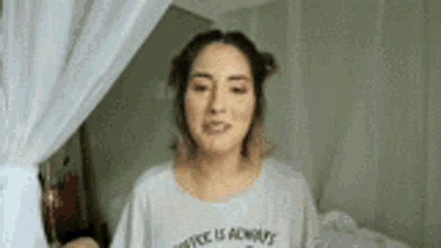 a woman is standing in front of a canopy bed wearing a t-shirt that says `` advice is always '' .
