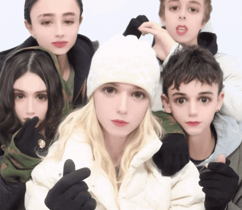 a group of people are posing for a picture and one of the girls is wearing a white hat