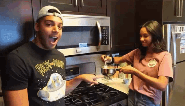a man wearing a rick and morty t-shirt cooking with a woman