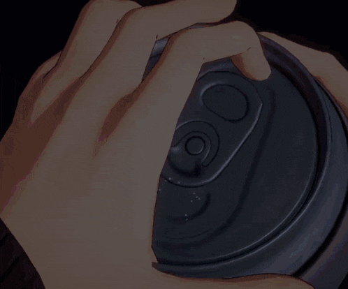 a close up of a person opening a soda can with the letter o on it
