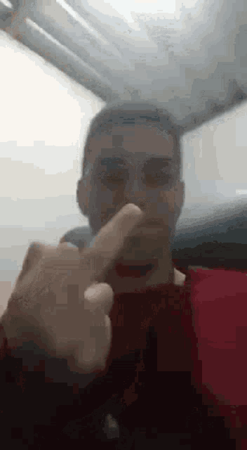 a man is giving the middle finger to the camera while sitting in a chair .