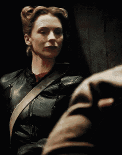 a woman in a black leather jacket is looking at something