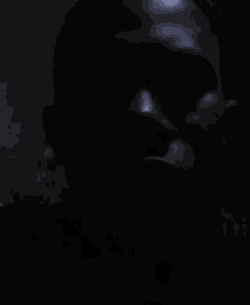 a close up of a man 's face in the dark with sunglasses on