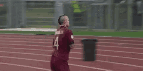a soccer player with the number 4 on his jersey is waving his hand