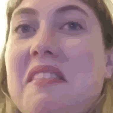 a close up of a woman 's face with a surprised look on her face .