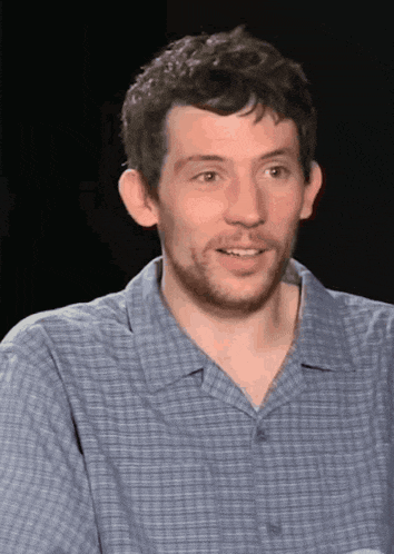 a man with a beard wearing a blue plaid shirt