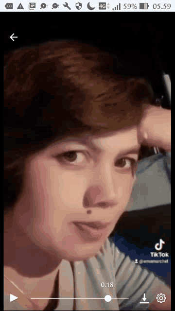 a woman 's face is shown on a cell phone screen with a tik tok app open
