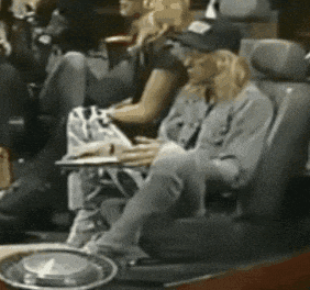 a woman in a hat sits in a car seat with a notebook on her lap