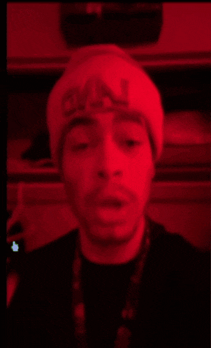 a man wearing a red hat with the word chanel on it