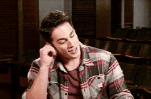 a man in a plaid shirt is talking on a phone