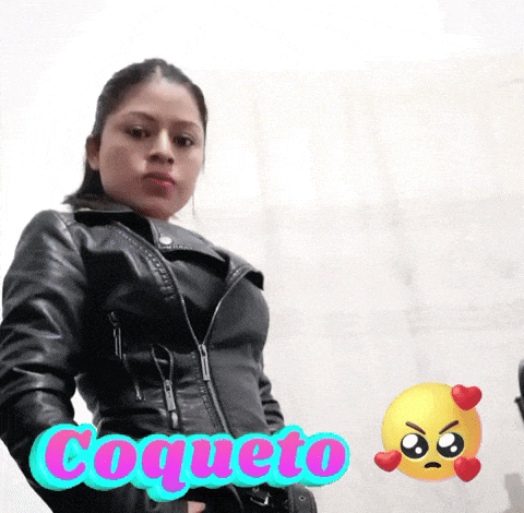 a woman in a black leather jacket is standing in front of a wall that says " coqueto "