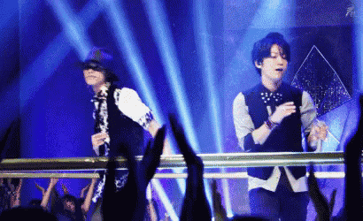 two men are dancing on stage in front of a crowd .
